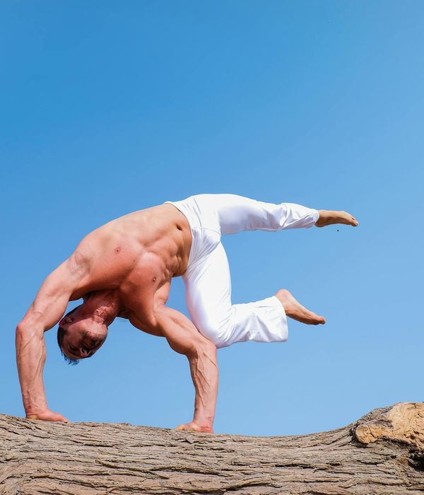 Man performing a powerful yoga pose, showcasing strength and balance.