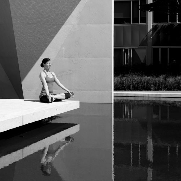 Woman in a serene yoga pose in a minimalist, calming environment.
